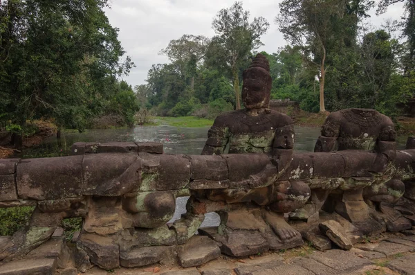 Statues of ancient khmer warrior heads carry giant snake decorat