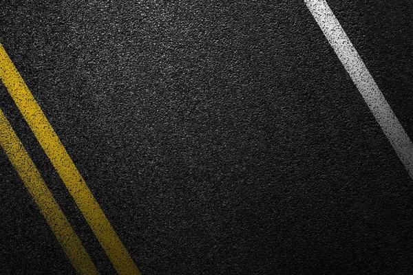 Level asphalted road with a dividing white and yellow stripes. The texture of the tarmac, top view.