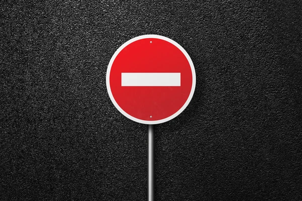 Red road sign of the circular shape on a background of asphalt. No entry. The texture of the tarmac, top view.