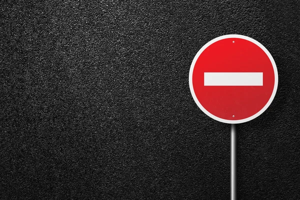 Red road sign of the circular shape on a background of asphalt. No entry. The texture of the tarmac, top view.