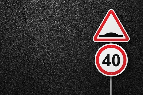 Road signs of the circular and triangular shape on a background of asphalt. Artificial roughness. Speed limit. The texture of the tarmac, top view.
