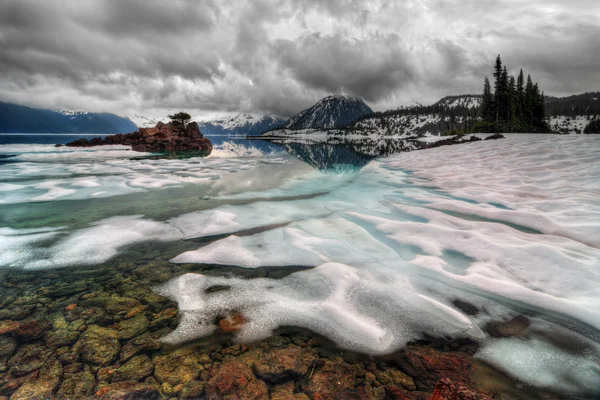 Almost frozen mountain lake shore