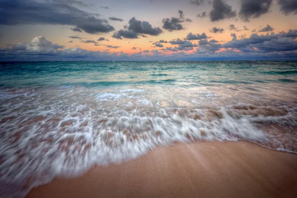 Waves cresting onto a sandy beach