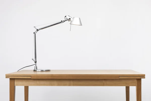A aluminum lighting stand on the wood desk(table) isolated white.