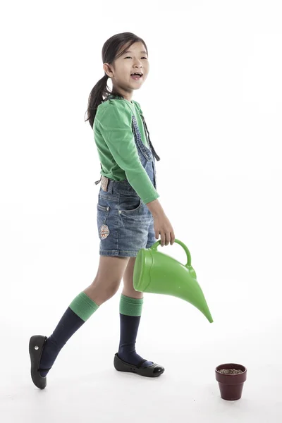 A child with watering tool and flower pot