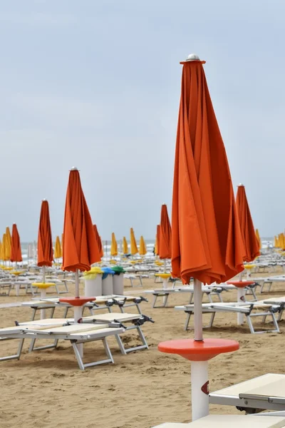 Parasols and deck chairs on the beach during a storm in rough seas, at lignano sabbiadoro Italy