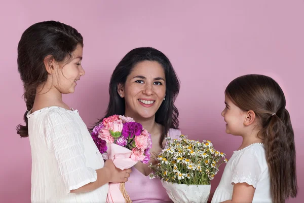 Girls giving flowers to their mother