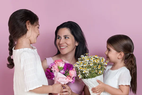 Girls giving flowers to their mother