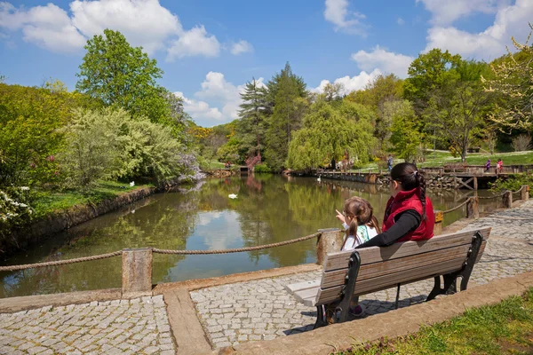 Mother and daughter sitting on bench