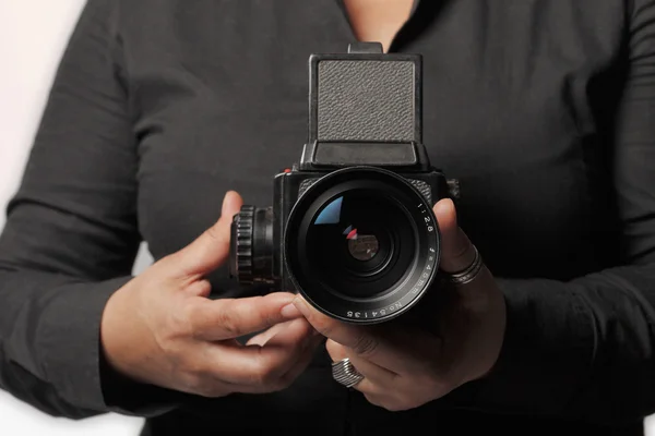 Woman holding retro photo camera