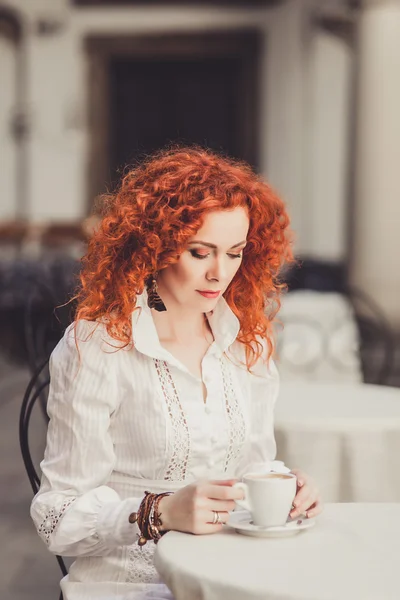 Girl with red hair in  cafe