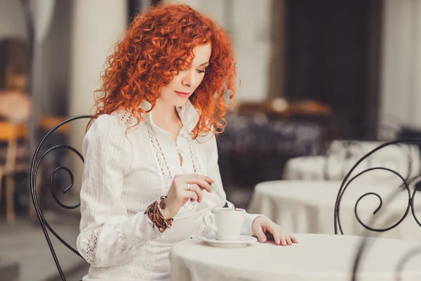 Girl with red hair in  cafe