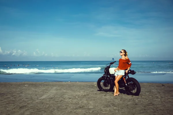 Woman sitting on vintage custom motorcycle