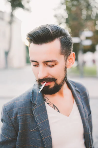 Guy with a beard  smoking a cigarette
