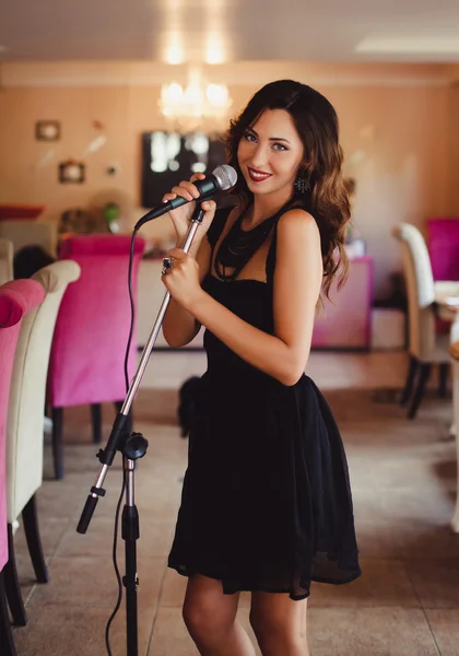 Beautiful girl singing into  microphone