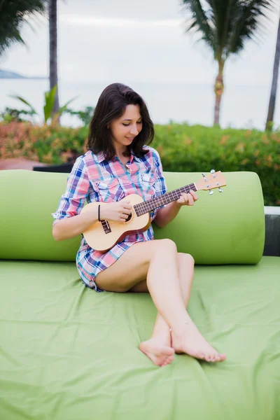 Young woman playing ukulele