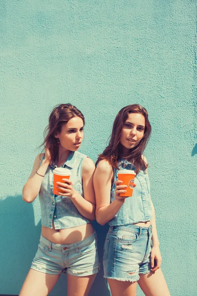 Sisters twins drinking coffee