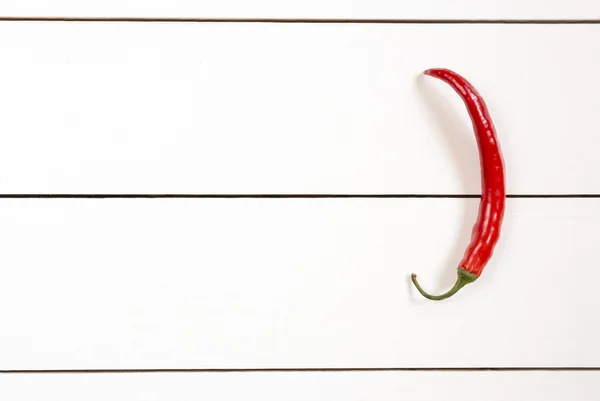 Red hot chili pepper on white wooden table