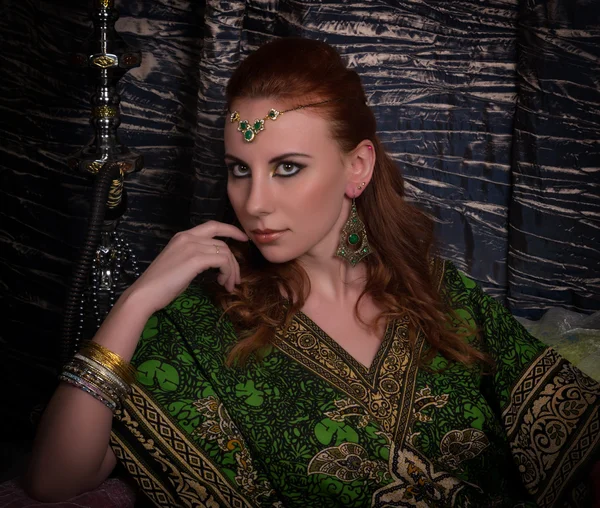 Closeup of Beautiful caucasian woman dressed in oriental style with oriental patterns on the hands and face, with numerous bracelets