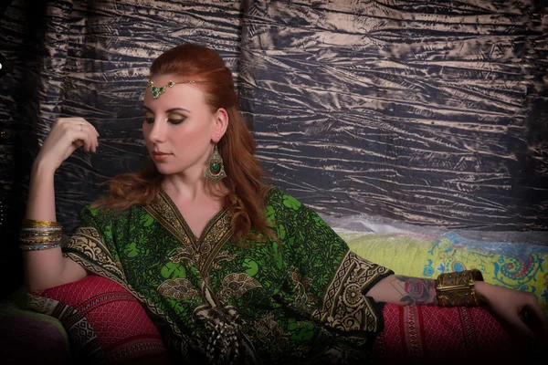 Closeup of Beautiful caucasian woman dressed in oriental style with oriental patterns on the hands and face, with numerous bracelets