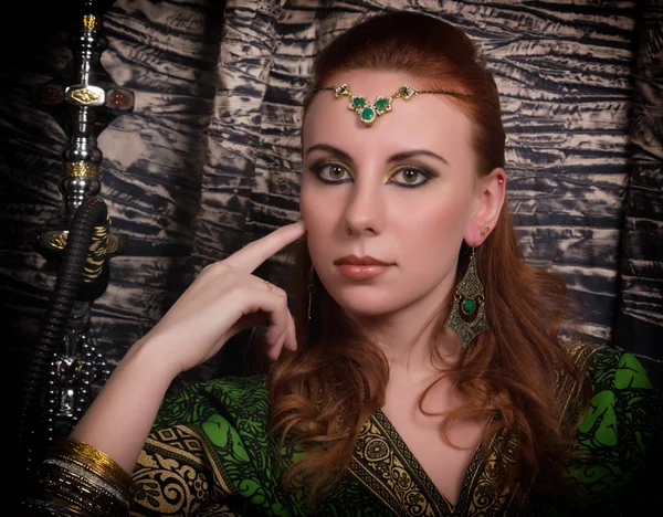 Closeup of Beautiful caucasian woman dressed in oriental style with oriental patterns on the hands and face, with numerous bracelets