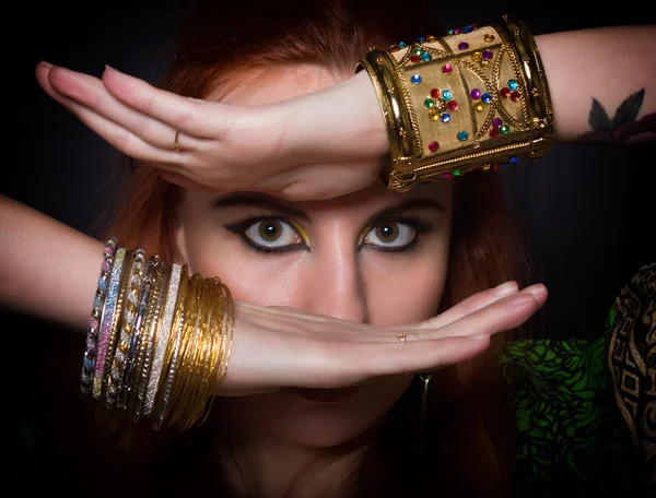 Close-up portrait of a beautiful girl dressed in Oriental style, with oriental decorations. close-up of eyes and hands with a lot of bracelets