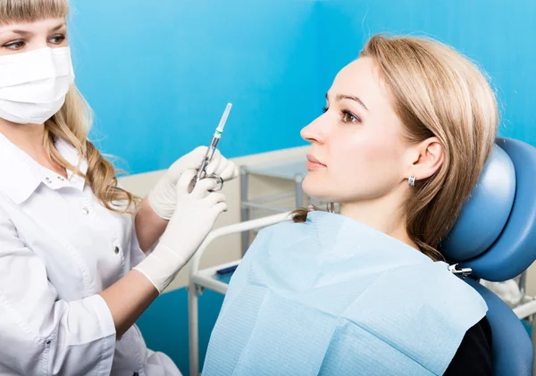 The reception was at the female dentist. Doctor examines the oral cavity on tooth decay. Caries protection. doctor puts the patient an anesthetic injection.