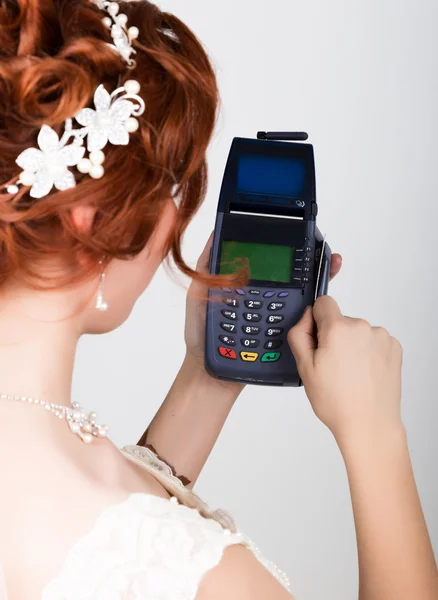 Payment card in a bank terminal. The concept of of electronic payment. Closeup of a beautiful bride holding credit card over payment terminal