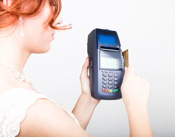 Payment card in a bank terminal. The concept of of electronic payment. Closeup of a beautiful bride holding credit card over payment terminal