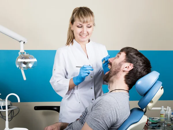 Doctor examines the oral cavity on tooth decay. Caries protection. Tooth decay treatment. Dentist working with dental polymerization lamp in oral cavity