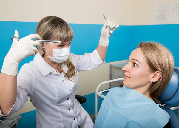 Doctor examines the oral cavity on tooth decay. Caries protection. Tooth decay treatment. Dentist working with dental polymerization lamp in oral cavity