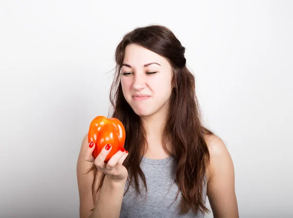 Beautiful young woman eating an vegetables. holding a red pepper. healthy food - strong teeth and body concept