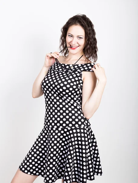 Beautiful young woman removes sun glasses, wears a dress with polka dots. expressing different emotions