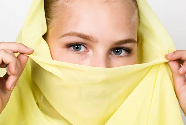 Close-up beautiful mysterious eyes eastern woman wearing a yellow hijab