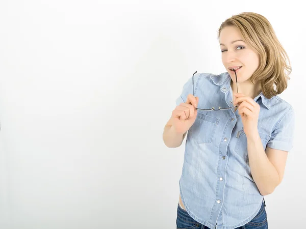 Beautiful young woman has many different emotions from happiness, sadness to anger and stress. She is wearing a denim shirt and glasses