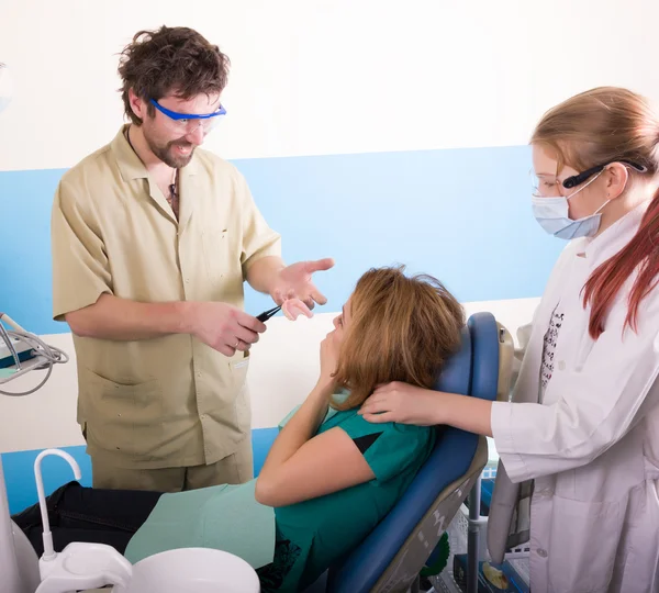 Crazy dentist treats teeth of the unfortunate patient. The patient is terrified.