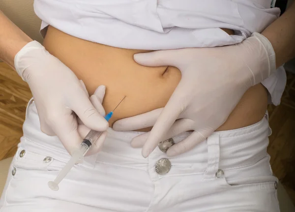 Closeup of a slim girls hands as she gives herself a shot. She holding a syringe