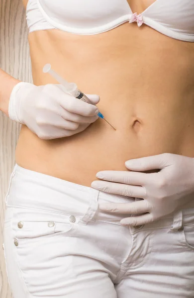 Closeup of a slim girls hands as she gives herself a shot. She holding a syringe