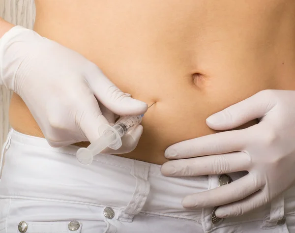 Closeup of a slim girls hands as she gives herself a shot. She holding a syringe