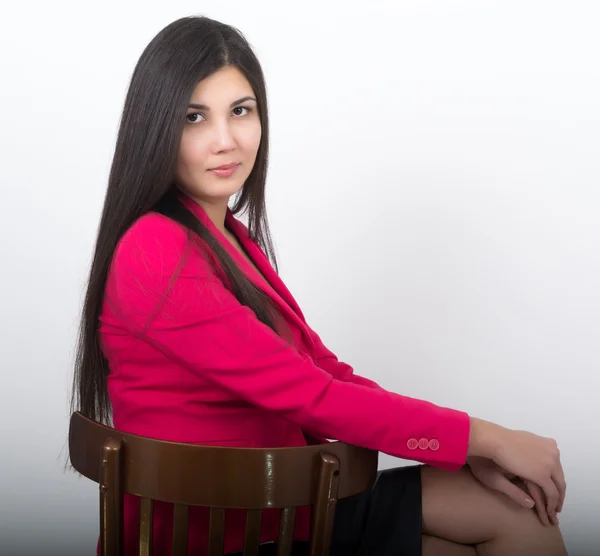 A young pretty slim asian woman in a black leather skirt and a red jacket