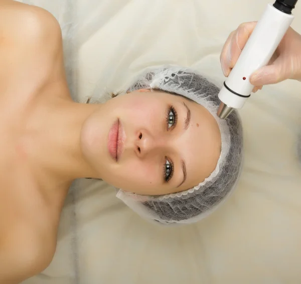 Beautician examining the face of a young female client at spa salon. getting rf-lifting in a beauty salon. Professional consultation