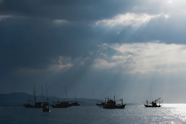 Sunlight through the clouds, a fishing boat,