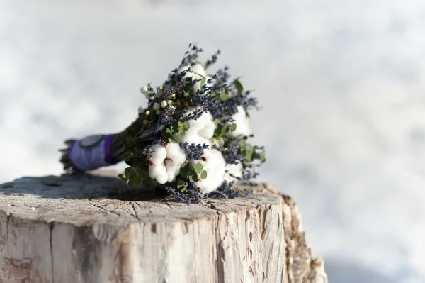 Beautiful wedding bridal bouquet on a stump of cotton and blue flowers
