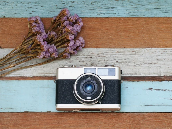 Vintage old camera with flower on the old wooden