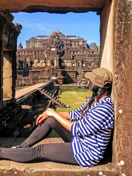Woman tourist look at Temple area named Baphuon in Angkor Thom