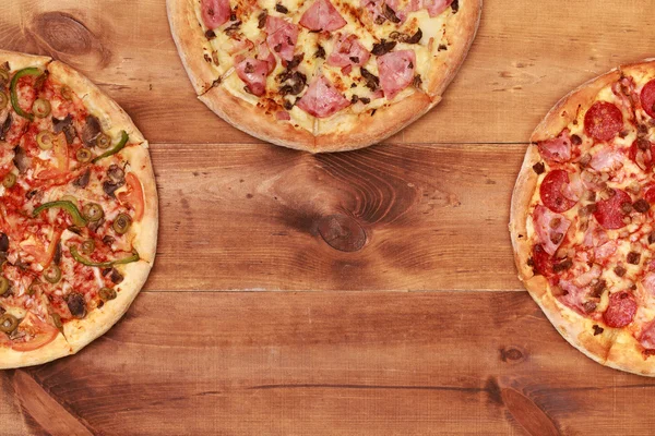 Three tasty pizzas on table