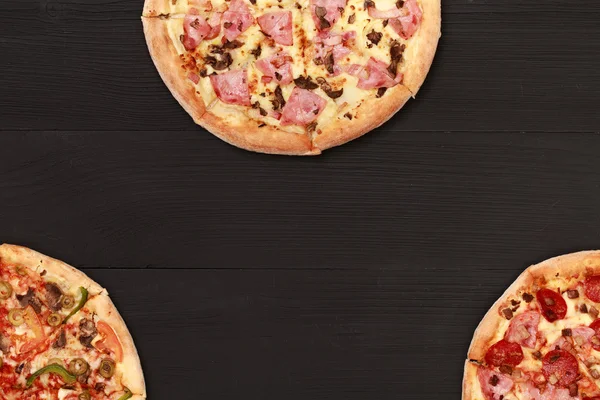 Three tasty pizzas on table