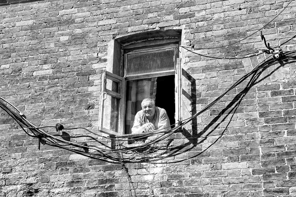 View of an old man looking out from a window