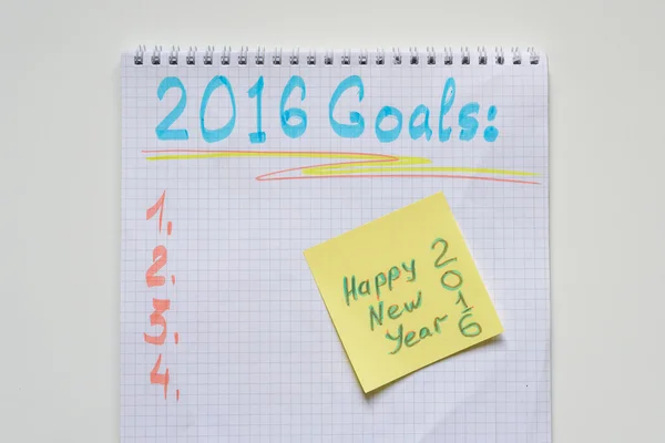 Notebook with yellow sticker and goals of year 2016. happy new year 2016 on yellow sticker