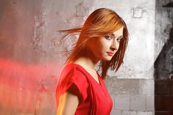 The beautiful natural young smiling woman of the brunette carrying a red dress.